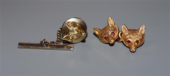 A single 9ct gold cufflink modelled as a pair of fox masks with ruby-set eyes and a 14k single fox mask dress stud.